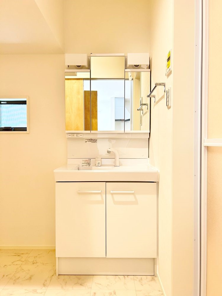 三面鏡の裏は収納スペースとなっており、物が多くなりがちな洗面台まわりをスッキリ保つことができます。※施工事例になります。実際と色やデザインが異なりますので詳しくはお問い合わせください。