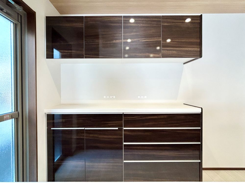 キッチン背面には、大容量のキャビネットを設置。引き出し収納と吊戸棚で、調理家電からストック品まですっきり整理整頓。生活感を隠しながら、空間を美しく保てます。