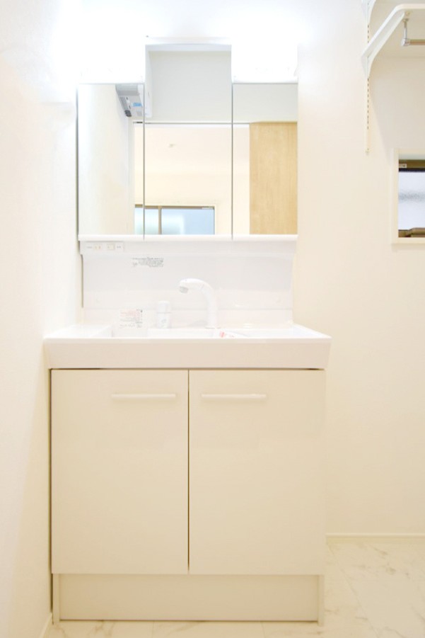 三面鏡の裏は収納スペースとなっており、物が多くなりがちな洗面台まわりをスッキリ保つことができます。※施工事例になります。実際と色やデザインが異なりますので詳しくはお問い合わせください。