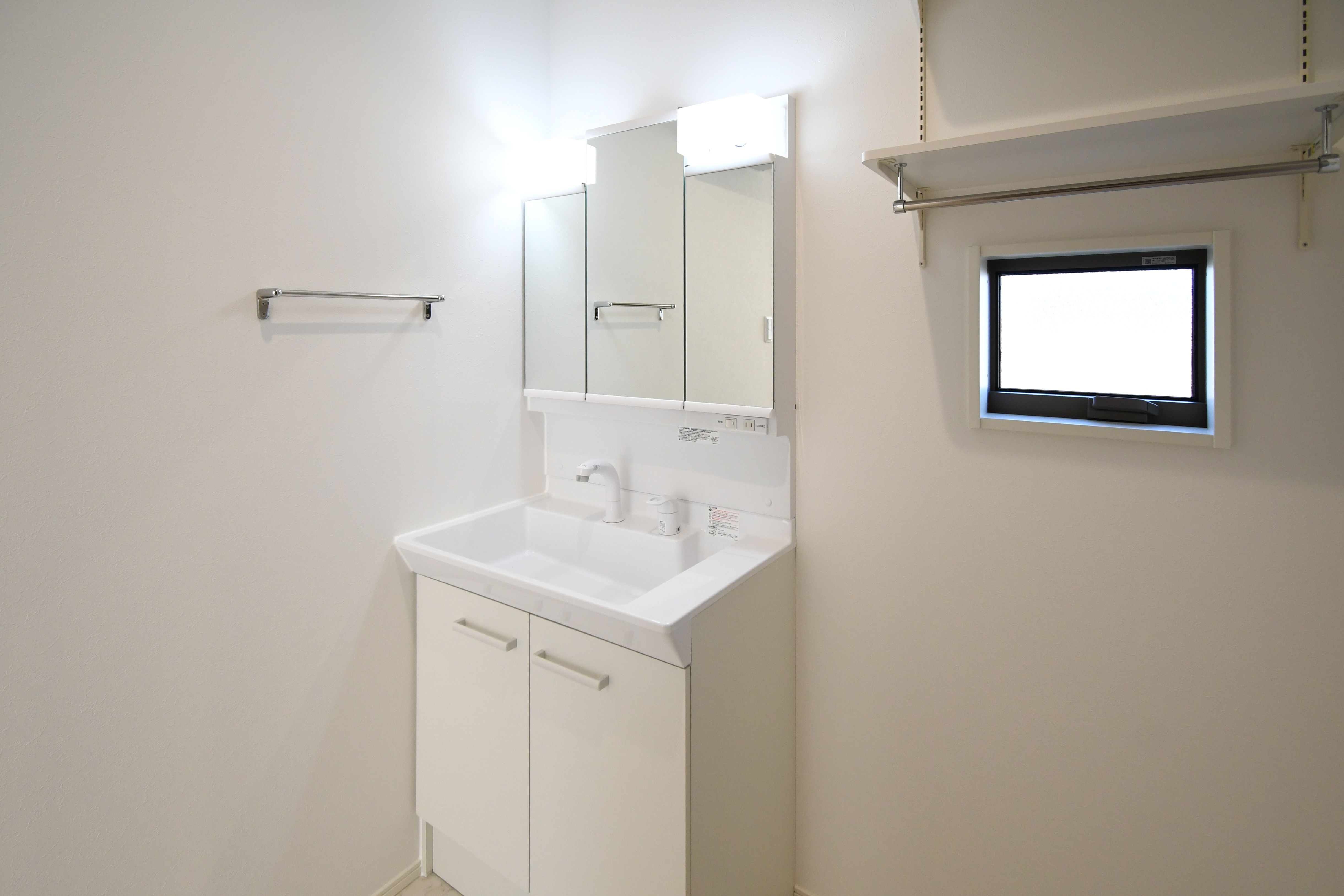 三面鏡の裏が収納になっており、化粧品や洗面用具などをすっきりと収納できます。※施工事例です。実際とは異なります。