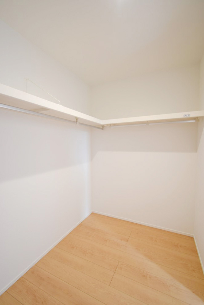 壁一面にハンガーパイプと上棚を設置。大容量収納力！ 春夏秋冬、季節ごとのお洋服を全てまとめてしまっておけるので、 季節の変わり目にタンスの入れ替えを行う衣替えが不要になります♪※施工事例になります。実際と色やデザインが異なりますので詳しくはお問い合わせください。